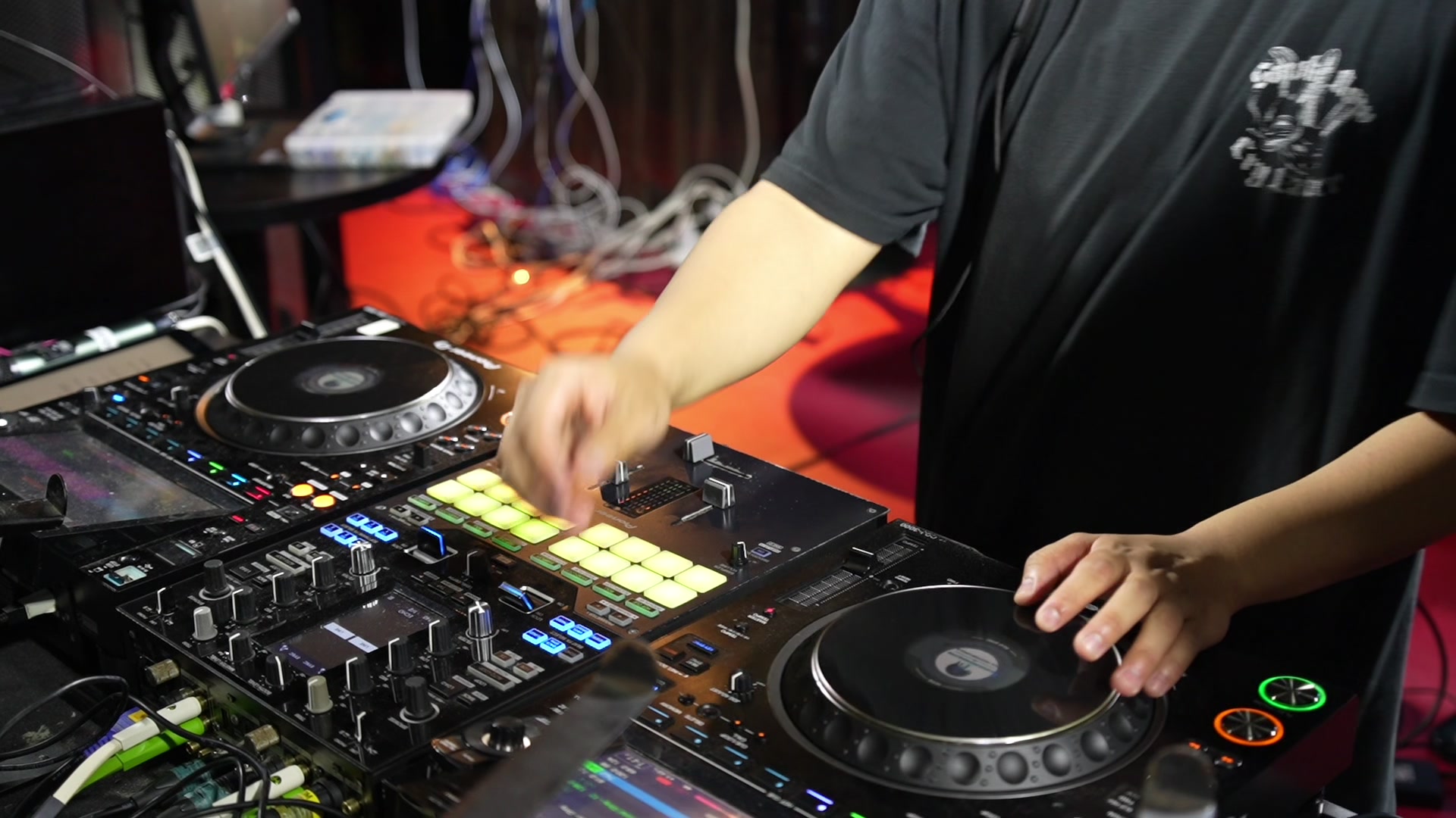 プレイ中のDJブース。デッキとミキサーを操作する手元。（当日の記録映像より）