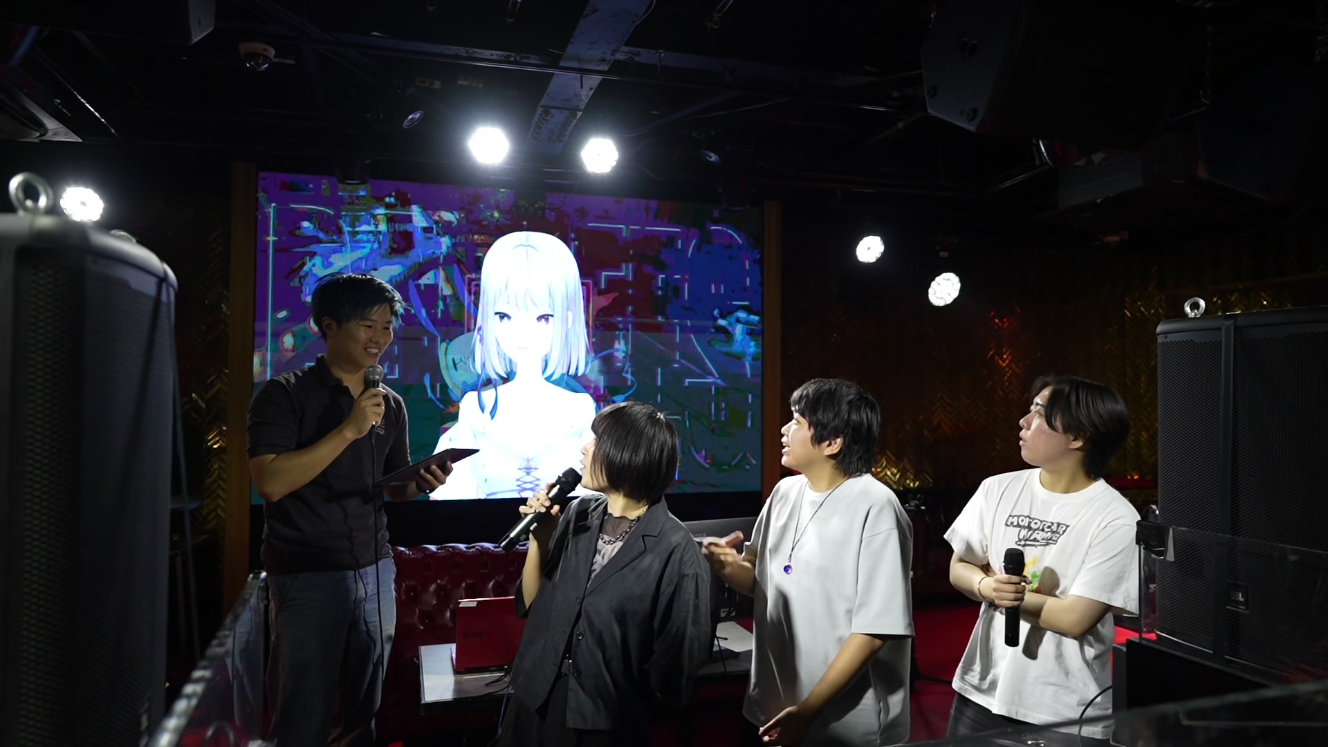 大型スクリーンに映る紫ノ花りおと、会場の出演者が同じ場でトーク。（当日の記録映像より）